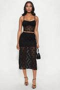 Woman wearing a black lace two-piece outfit on a white background