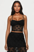 Woman wearing a black lace top and skirt on a white background