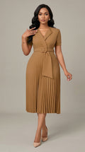 Woman wearing a brown pleated dress with a belt on a neutral background