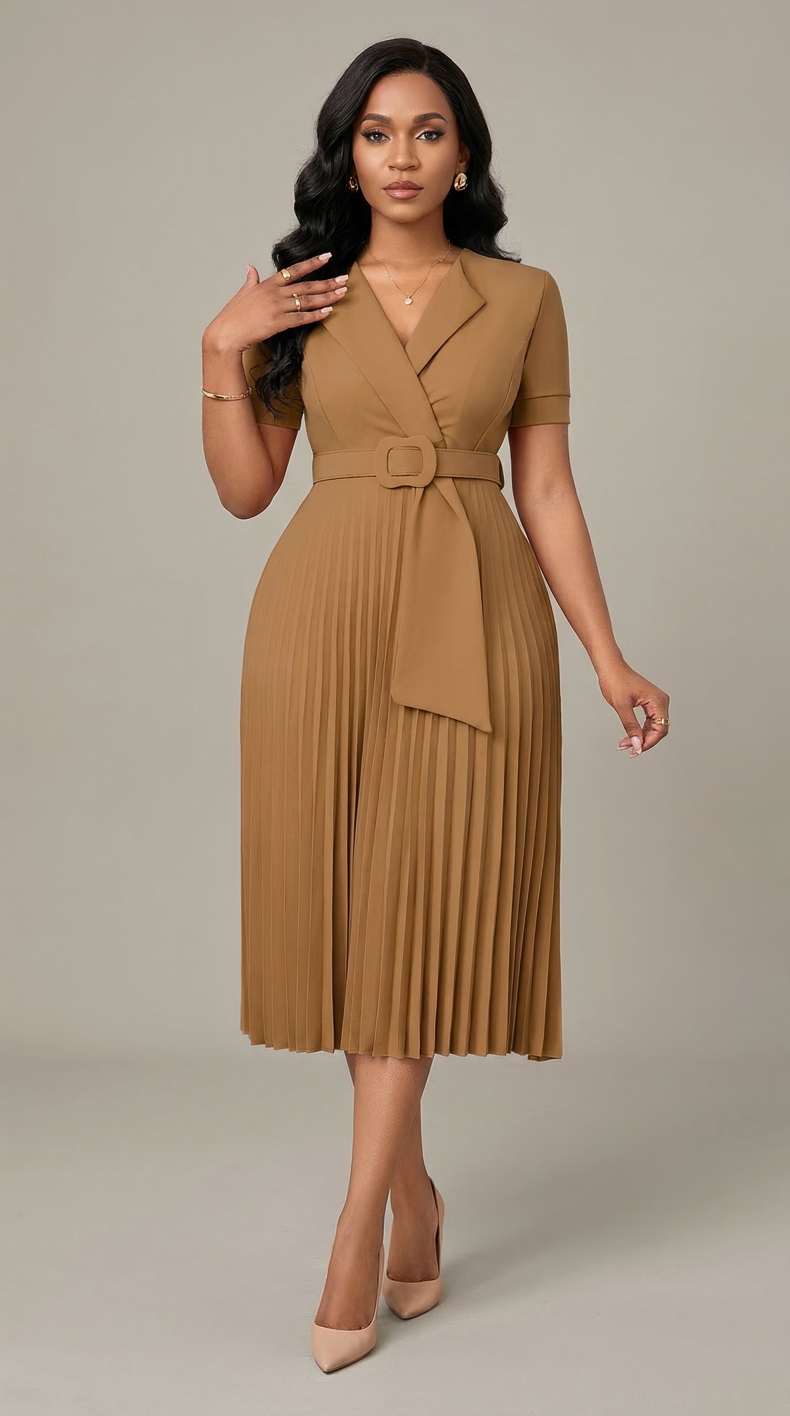 Woman wearing a brown pleated dress with a belt on a neutral background