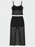 Flat lay of a black lace camisole and matching long skirt on a light grey background