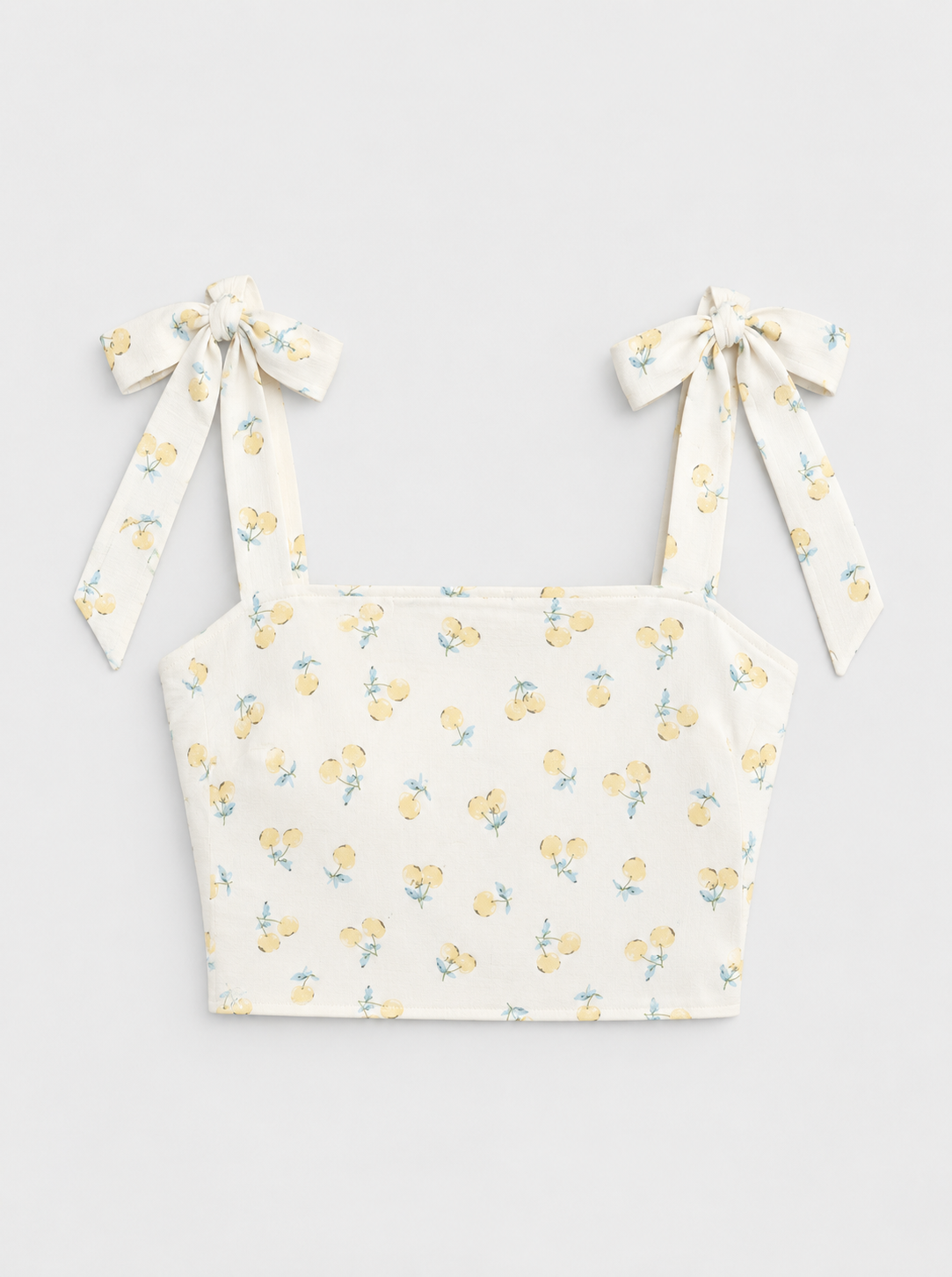 Flat lay of Shoulder Tie Smocked Cropped Top - Yellow Combo on a light grey background